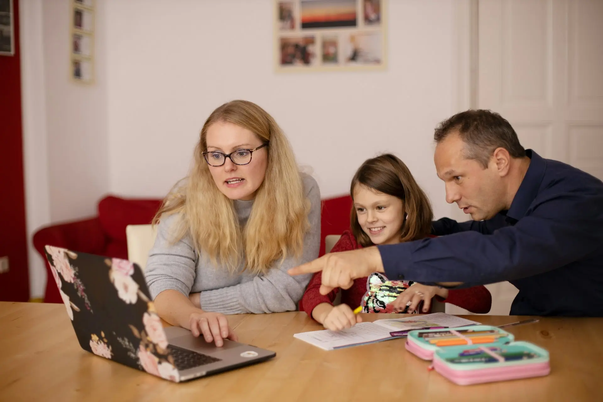 family helping homeschooled child use a laptop at home